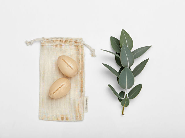 
                  
                    Marching Bambino Wooden egg shakers on Mesh eco friendly bag with eucalyptus leaves next to it
                  
                